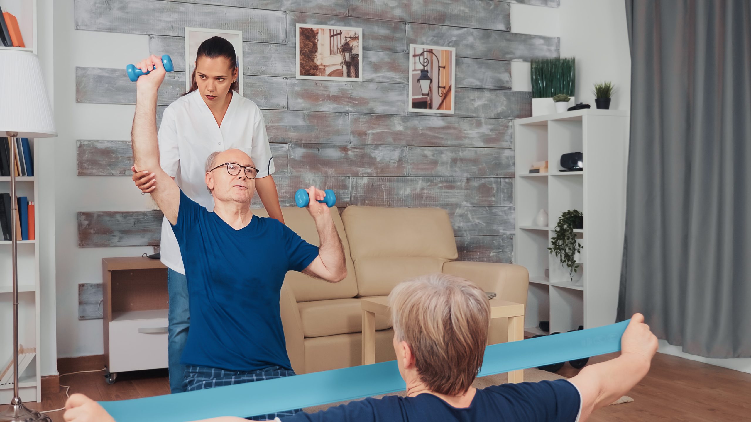 Nurse and senior patients Nurse doing physical therapy with senior couple